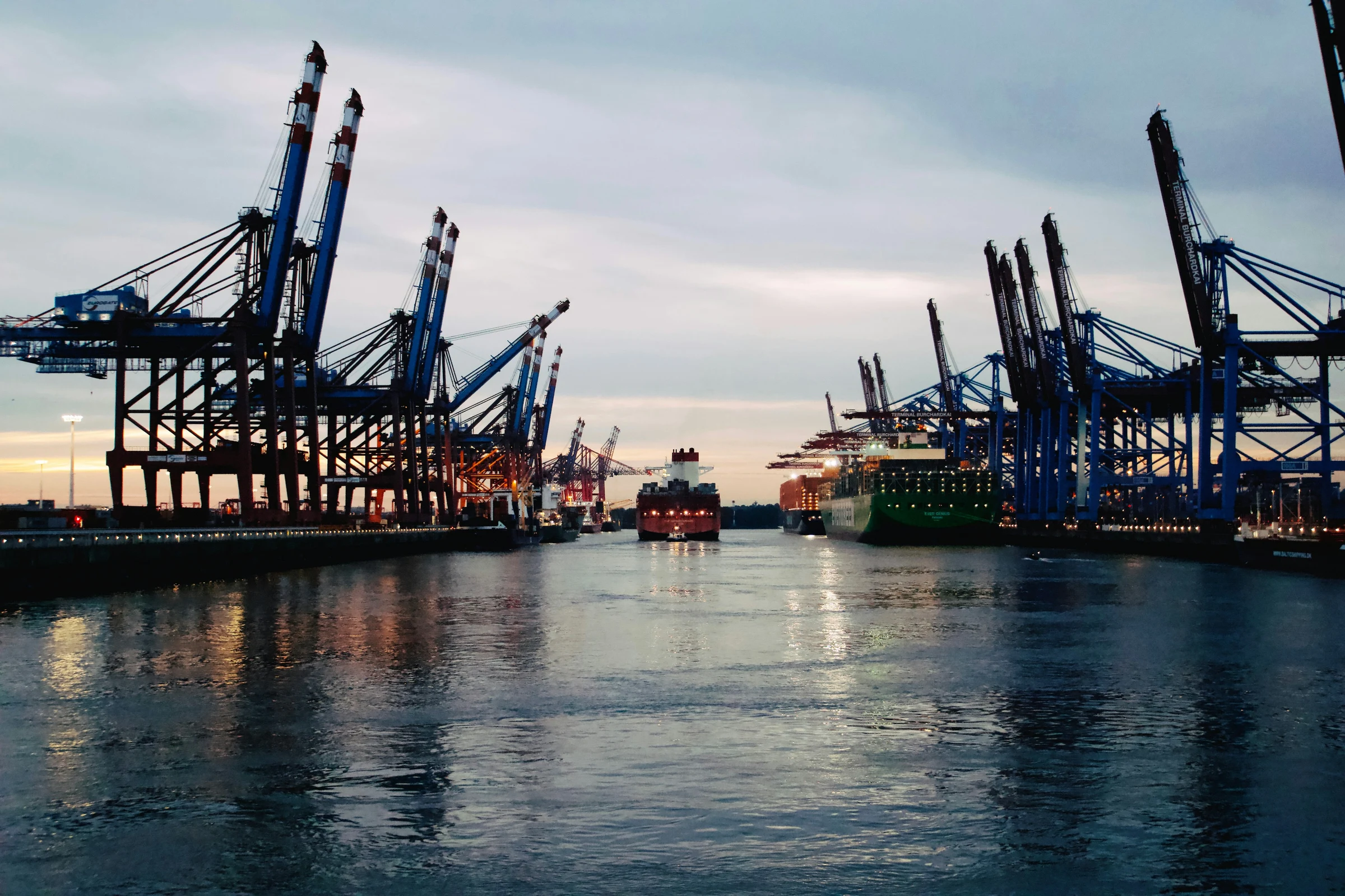 A working port with cargo and crane activity — the practical machinery of economic multiplier effects in motion.