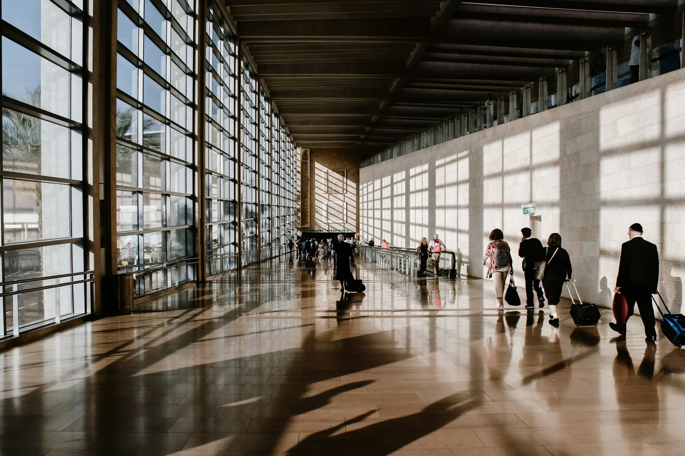 The departures hall of a major European international airport, with travellers moving through the terminal.